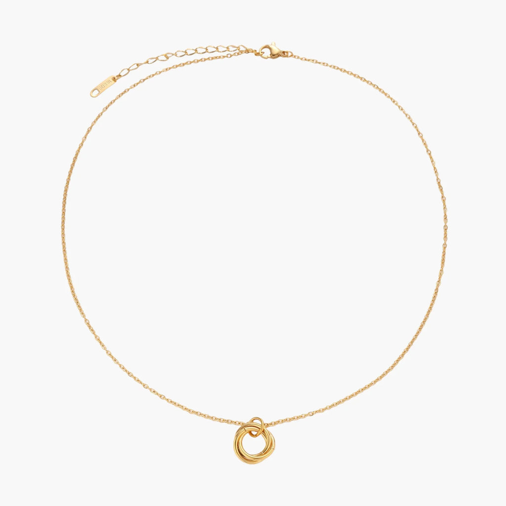 Delicate gold-plated necklace with three interlocking circle rings forming a minimalist knot pendant on cream background