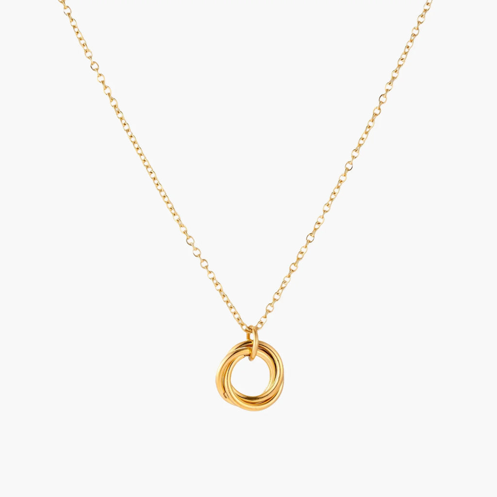 Delicate gold-plated necklace with three interlocking circle rings forming a minimalist knot pendant on cream background