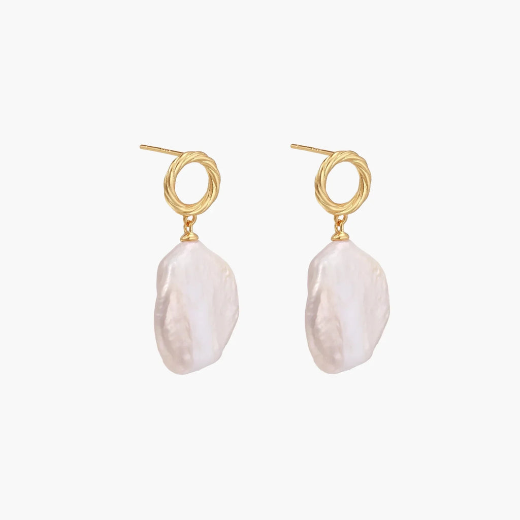 18K gold vermeil twisted circle studs with organic white baroque pearl drops on cream background
