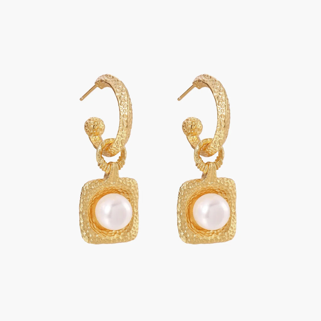 Pair of gold vermeil hoop earrings with textured square frames holding freshwater pearls on cream background