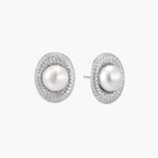 Oval rhodium-plated silver studs featuring freshwater pearls surrounded by pavÃ© crystal halo on white background