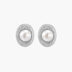 Oval rhodium-plated silver studs featuring freshwater pearls surrounded by pavÃ© crystal halo on white background