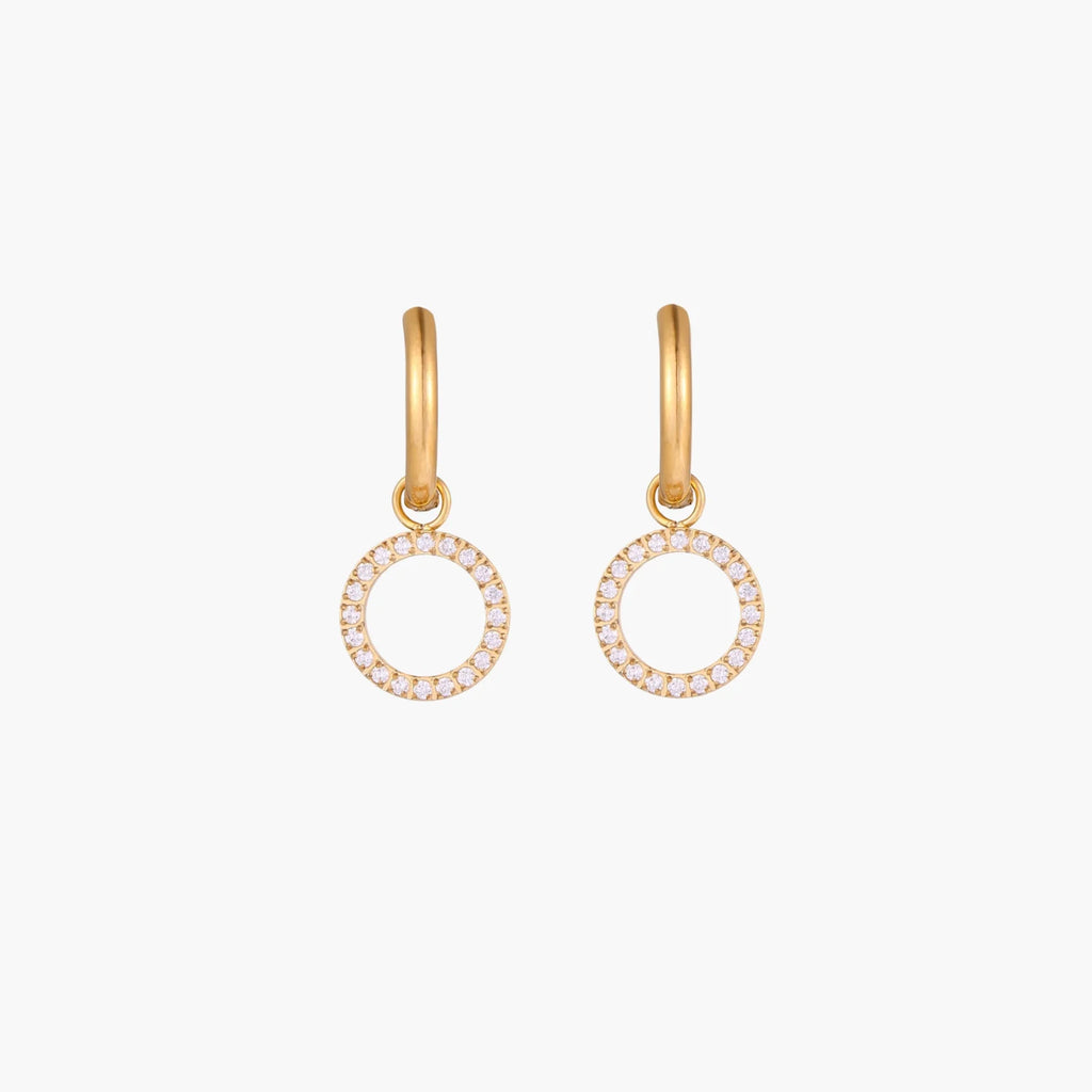 Gold-plated huggie hoop earrings with CZ-studded open circle charms on beige background