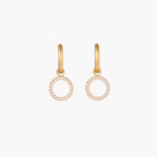 Gold-plated huggie hoop earrings with CZ-studded open circle charms on beige background