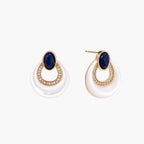 Gold drop earrings with oval lapis lazuli, crystal-paved frame, and iridescent mother-of-pearl teardrop on cream background