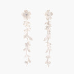 Long sterling silver drop earrings with delicate floral vine design and crystal accents on white background