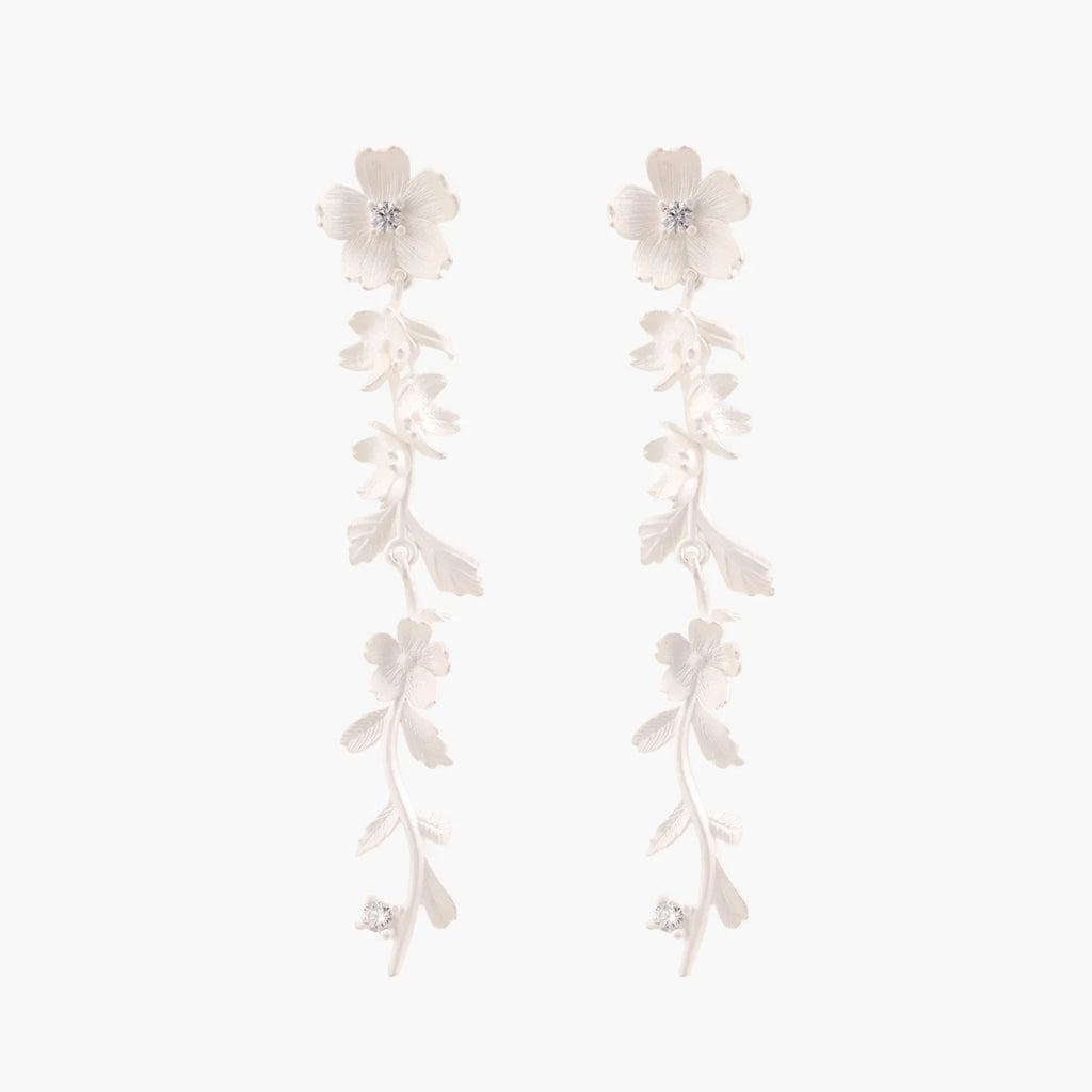Long sterling silver drop earrings with delicate floral vine design and crystal accents on white background
