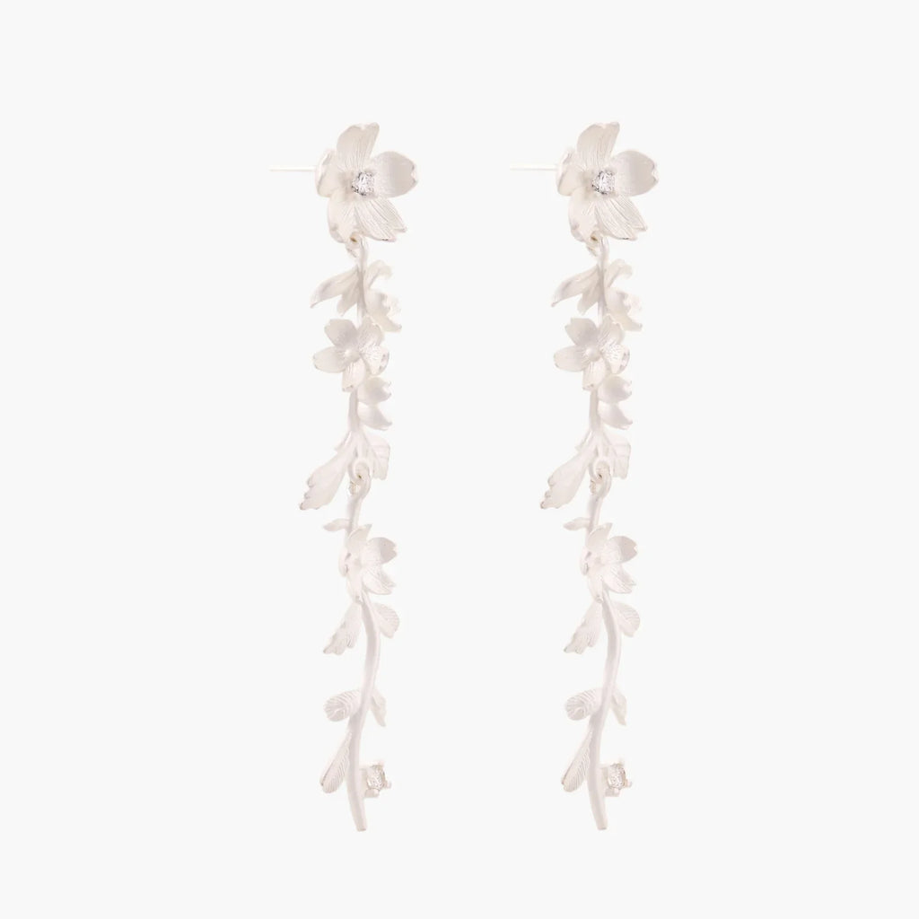 Long sterling silver drop earrings with delicate floral vine design and crystal accents on white background
