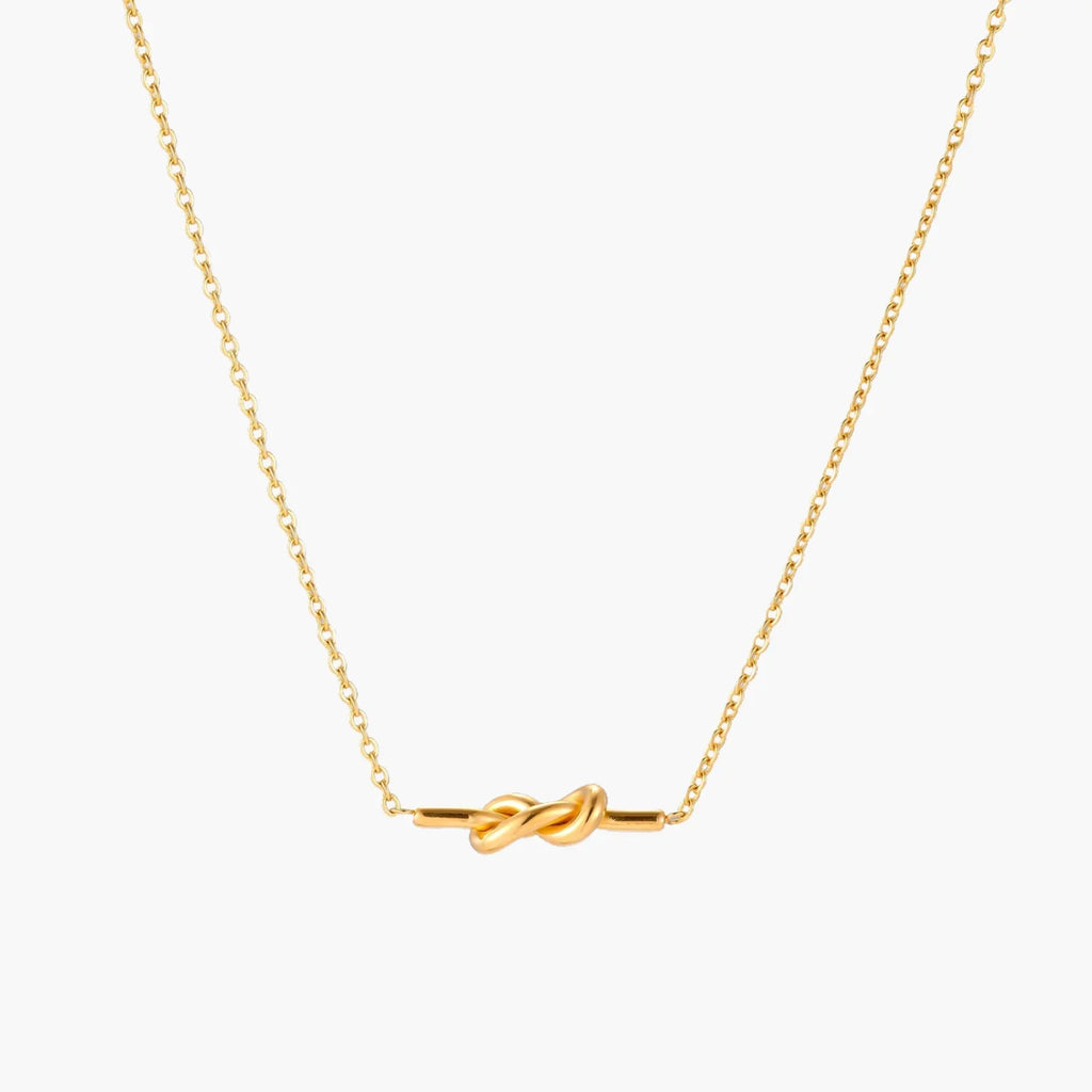 Dainty 18K gold plated necklace with infinity knot pendant on delicate chain against white background