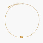 Dainty 18K gold plated necklace with infinity knot pendant on delicate chain against white background