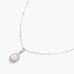 Oval sterling silver pendant with crystal halo surrounding a white freshwater pearl on delicate chain