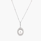 Oval sterling silver pendant with crystal halo surrounding a white freshwater pearl on delicate chain