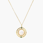 Gold pendant necklace with circular orbital design, iridescent mother-of-pearl center, and green zirconia accents