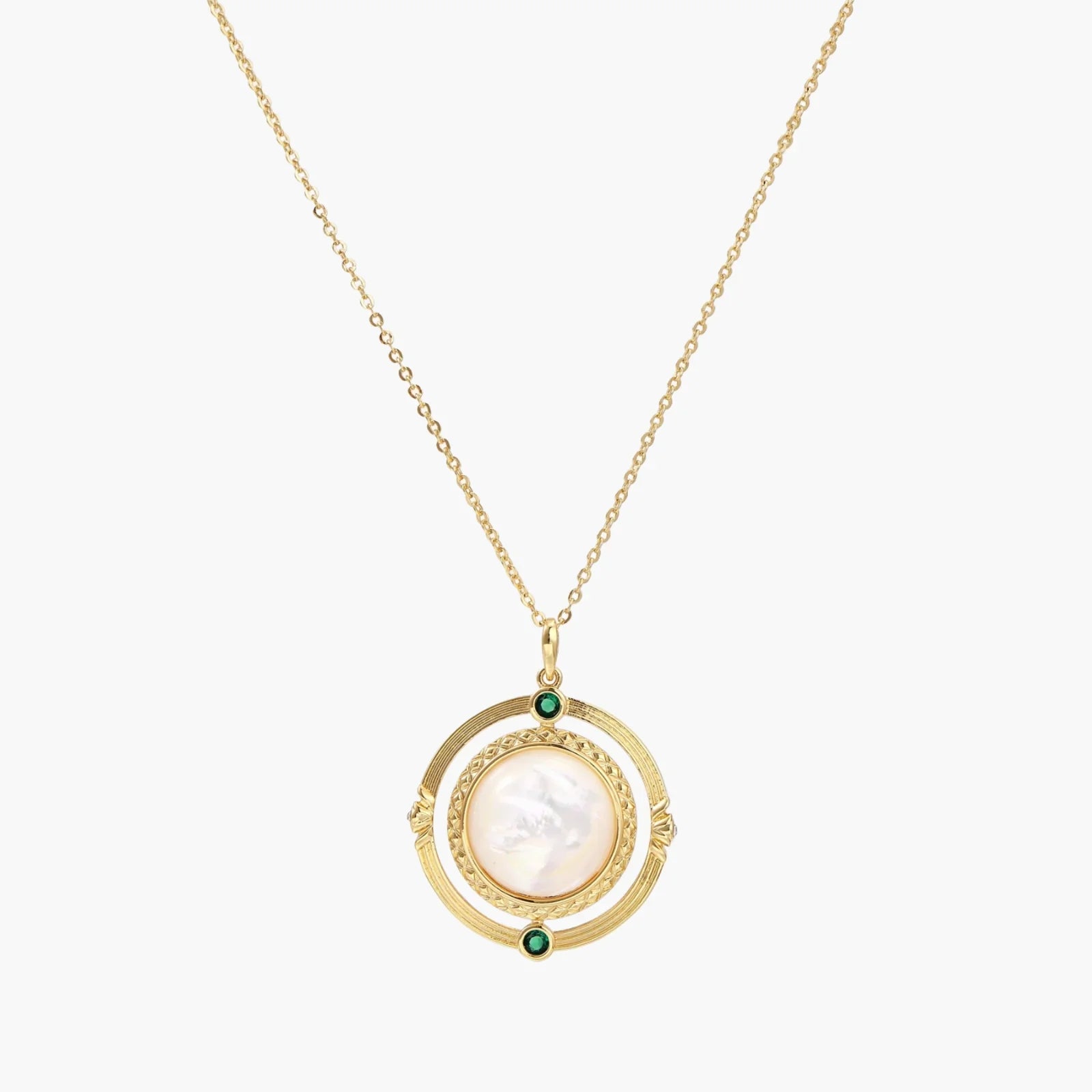 Gold pendant necklace with circular orbital design, iridescent mother-of-pearl center, and green zirconia accents