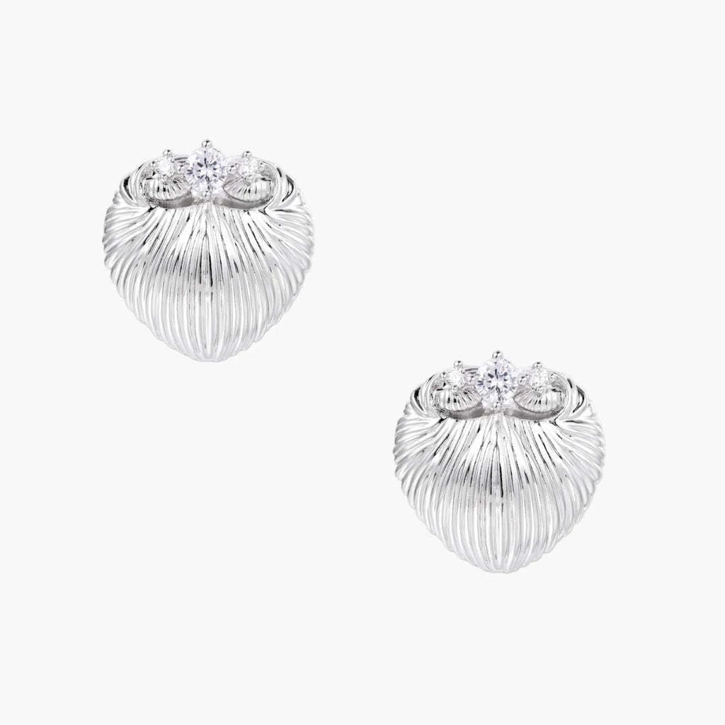 White gold-plated shell-textured stud earrings with three zirconia crystals on ridged surface against cream background.
