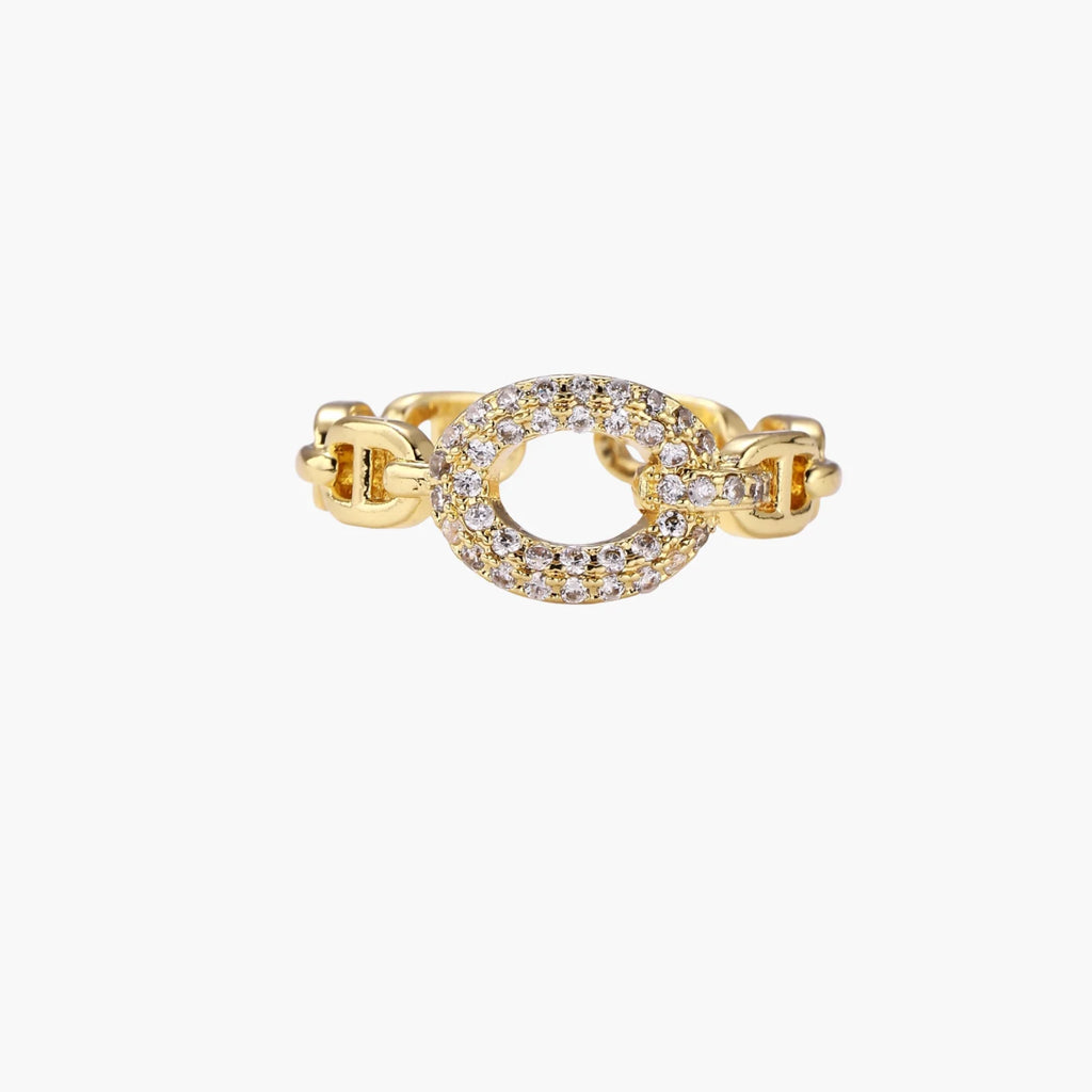 Gold-plated brass chain link ring with one oval CZ-pavÃ© segment on cream background, adjustable cuff style.