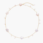 Gold vermeil chain with iridescent star-shaped baroque pearls and small round freshwater pearl drops on cream background.
