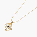 Gold filigree pendant with quatrefoil design, deep blue lapis lazuli center, clear crystal accents on ball chain