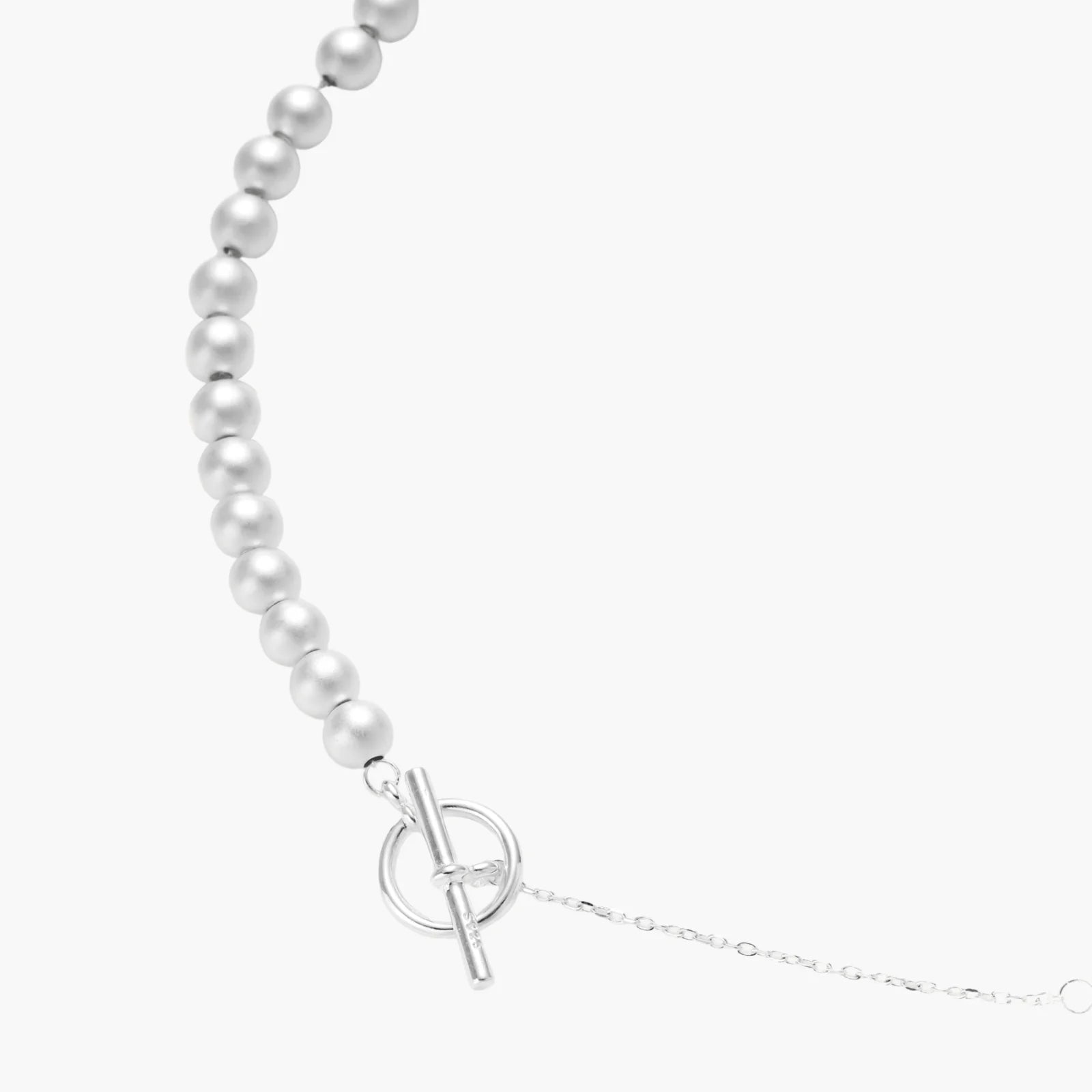 Long sterling silver beaded necklace with graduated sphere design, toggle clasp, and delicate chain extension on white background