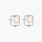 Rhodium-plated silver stud earrings with cushion frame, centered freshwater pearl, and tiny crystal accent