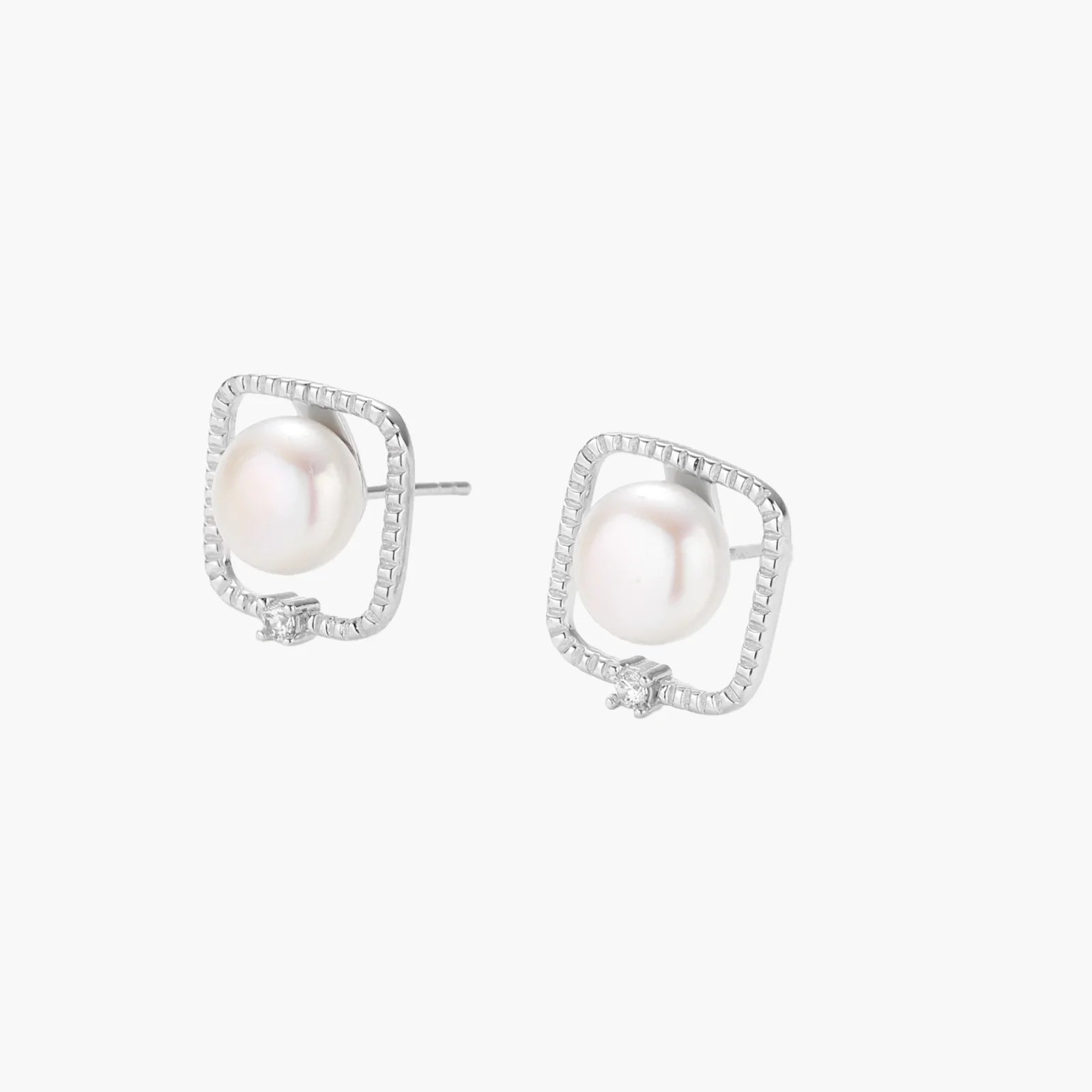 Rhodium-plated silver stud earrings with cushion frame, centered freshwater pearl, and tiny crystal accent