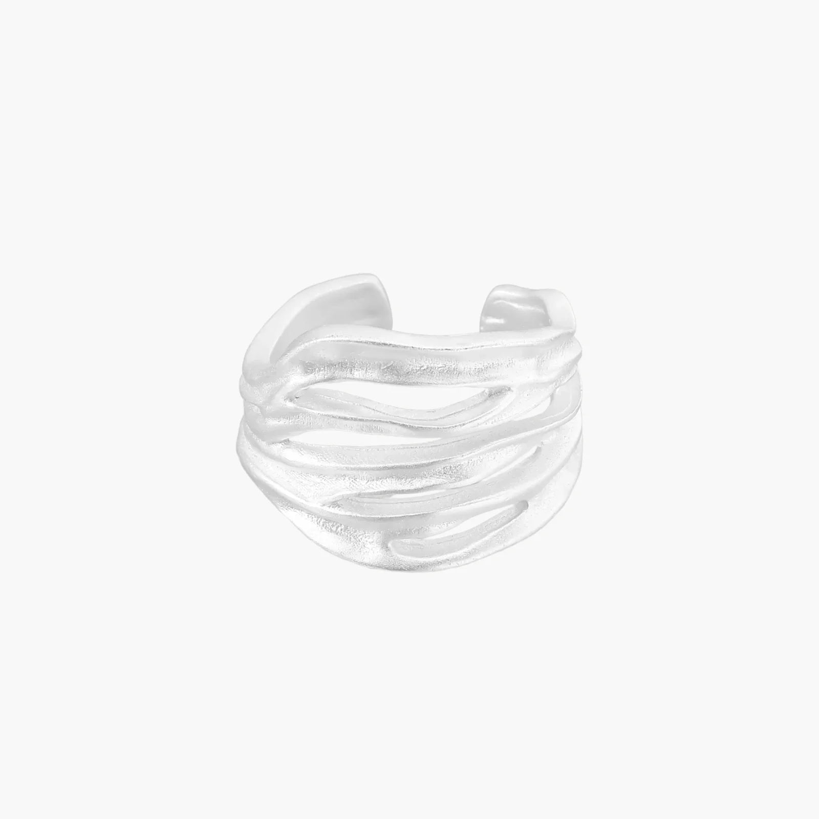 Wide sterling silver cuff ring with flowing wave patterns creating dimensional texture against cream background