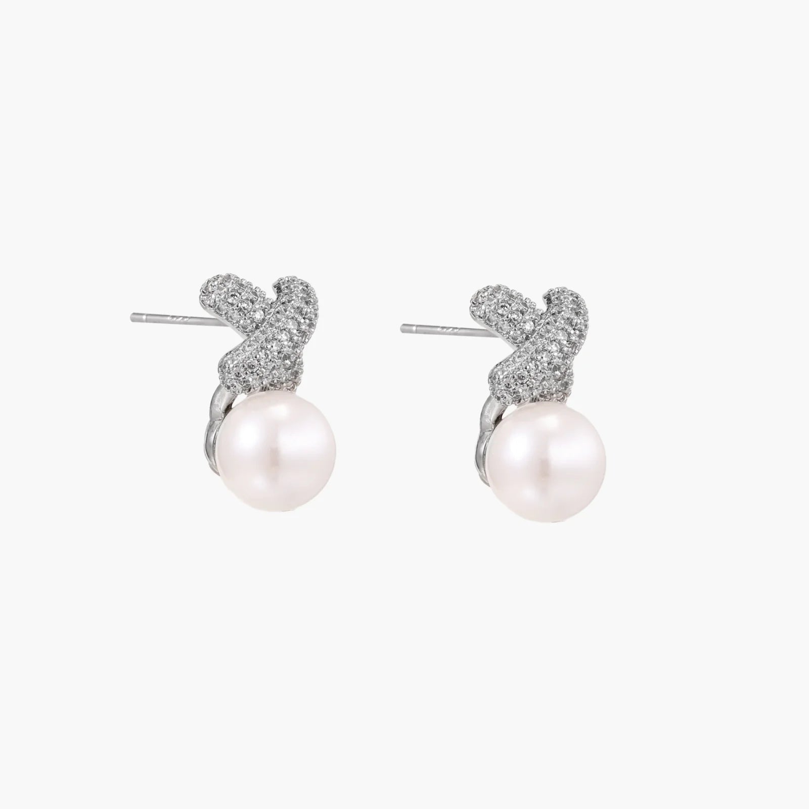White gold plated studs featuring pavÃ© X-shaped tops with freshwater pearl drops on cream background.