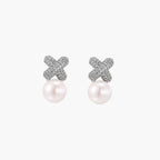 White gold plated studs featuring pavÃ© X-shaped tops with freshwater pearl drops on cream background.