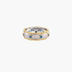Two-tone ring with brushed silver center, gold beaded edges, and blue zirconia stones on white background.