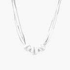 Sterling silver multi-strand necklace with three brushed round beads on cream background