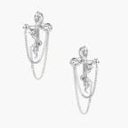 Sculptural white gold bow earrings with cascading chain details on neutral background